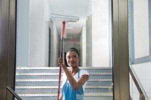 Woman cleaning glass door with squeegee