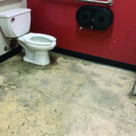 Dirty public restroom with mop and bucket
